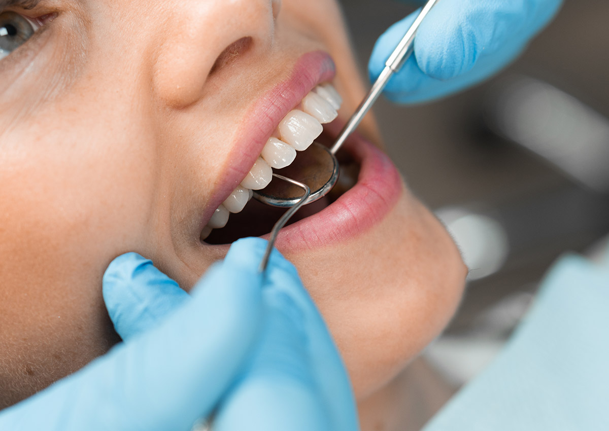 Cosmetic Dentistry - TRUST Dental Dentist looking in a patients mouth to perform dentistry treatment
